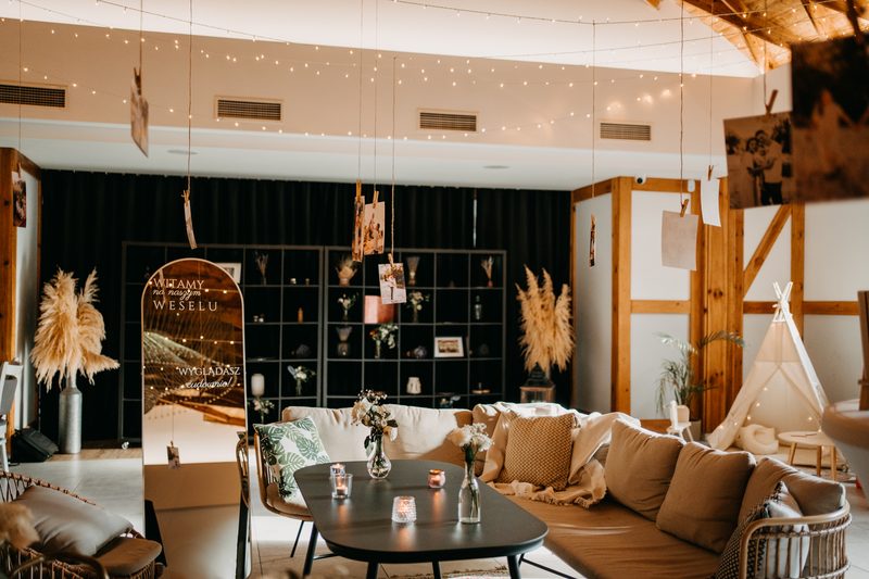 Sala Diamentowa jako strefa chillout: kanapy, dywany i lampki zawieszone pod drewnianym stropem
